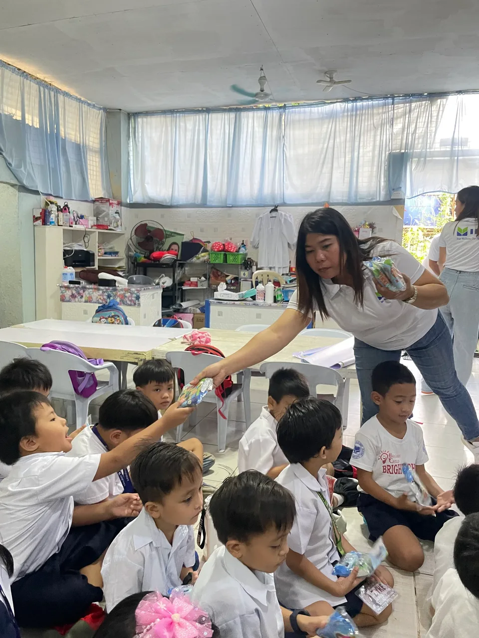 Schoolchildren in their classroom during an IPI Adopt-a-School handwashing and hygiene session, holding the hygiene kits they were given