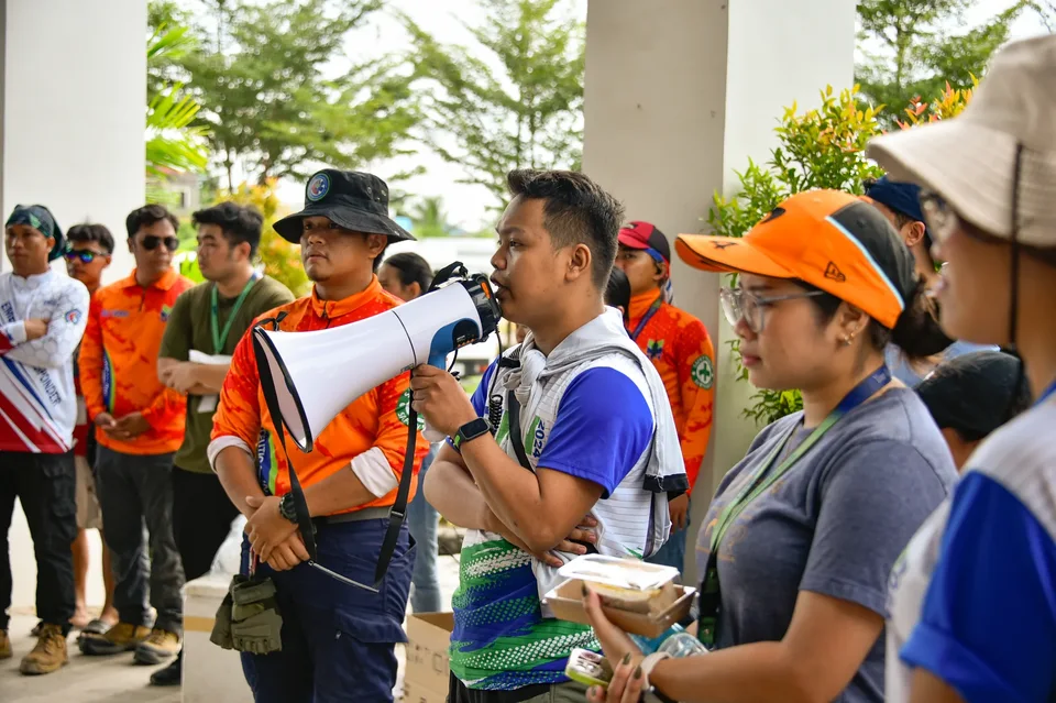 IPI employees planting mangrove propagules by hand across a tidal flat during the company’s EcoWellness mangrove planting day
