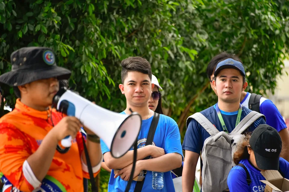 IPI employees planting mangrove propagules by hand across a tidal flat during the company’s EcoWellness mangrove planting day