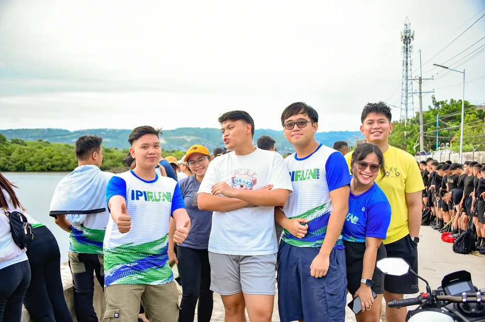 IPI employees planting mangrove propagules by hand across a tidal flat during the company’s EcoWellness mangrove planting day