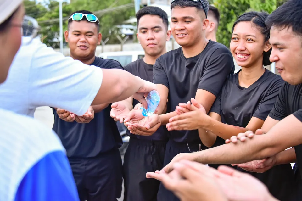 IPI employees planting mangrove propagules by hand across a tidal flat during the company’s EcoWellness mangrove planting day