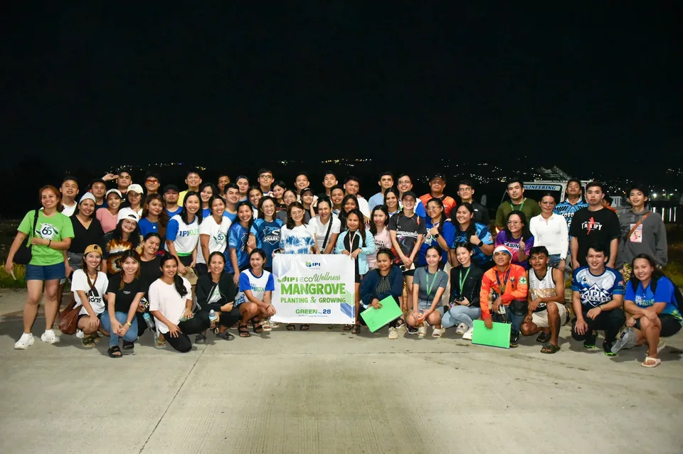 IPI employees planting mangrove propagules by hand across a tidal flat during the company’s EcoWellness mangrove planting day