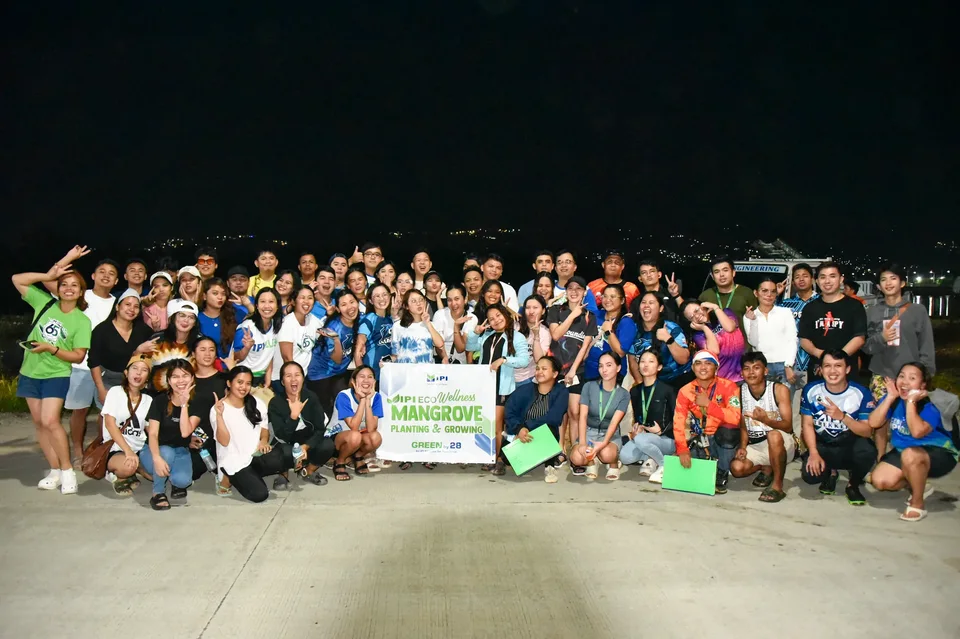 IPI employees planting mangrove propagules by hand across a tidal flat during the company’s EcoWellness mangrove planting day