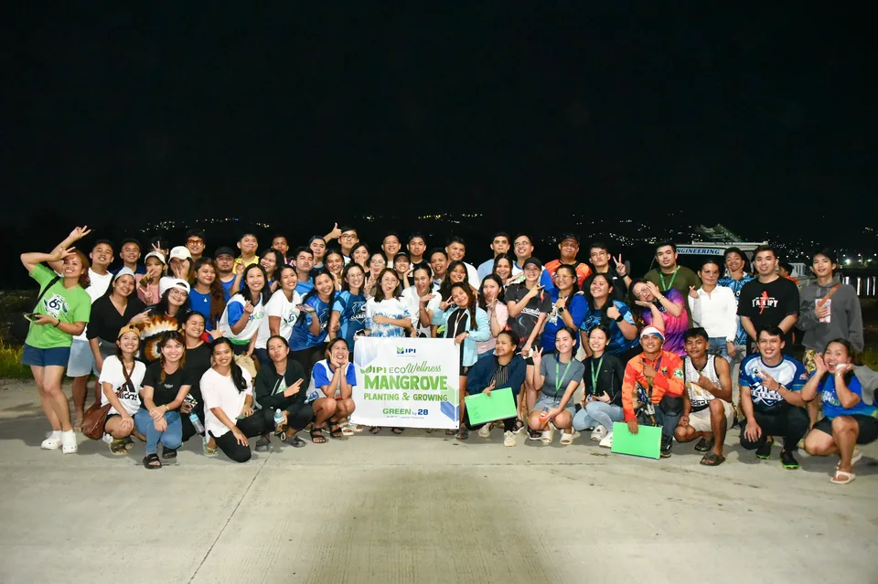 IPI employees planting mangrove propagules by hand across a tidal flat during the company’s EcoWellness mangrove planting day