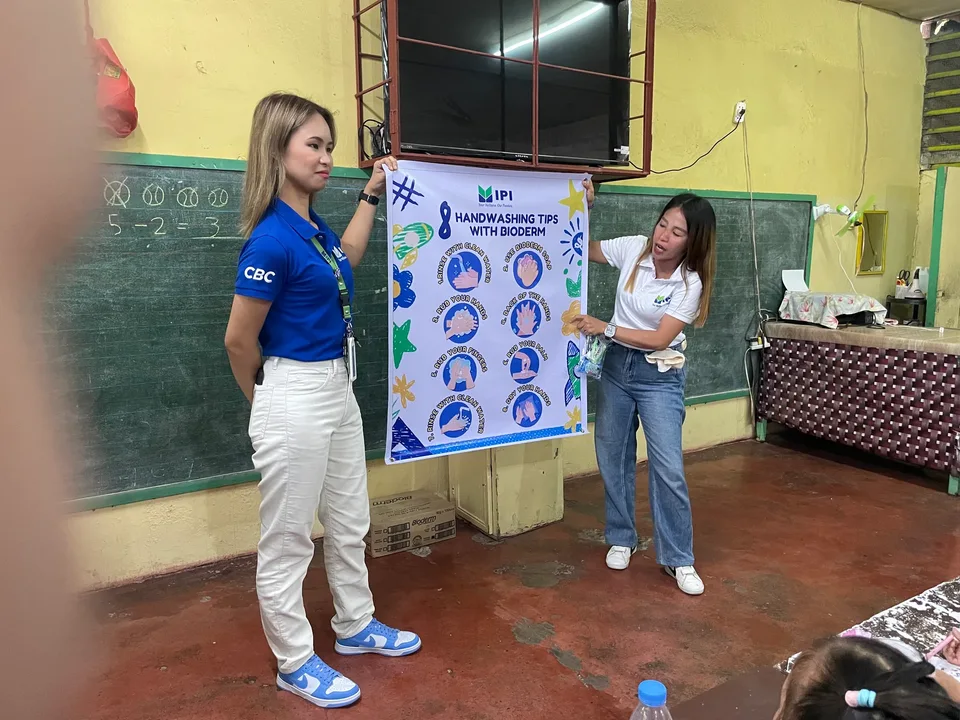 Schoolchildren in their classroom during an IPI Adopt-a-School handwashing and hygiene session, holding the hygiene kits they were given