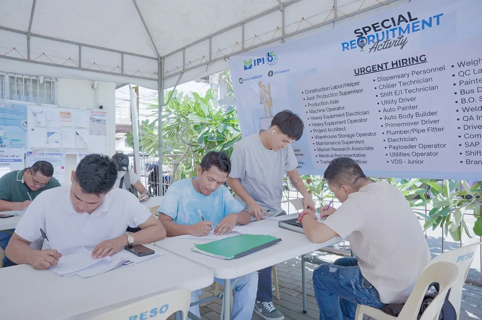 Applicants completing forms and meeting IPI recruiters at a PESO special recruitment activity held under tents in the city grounds