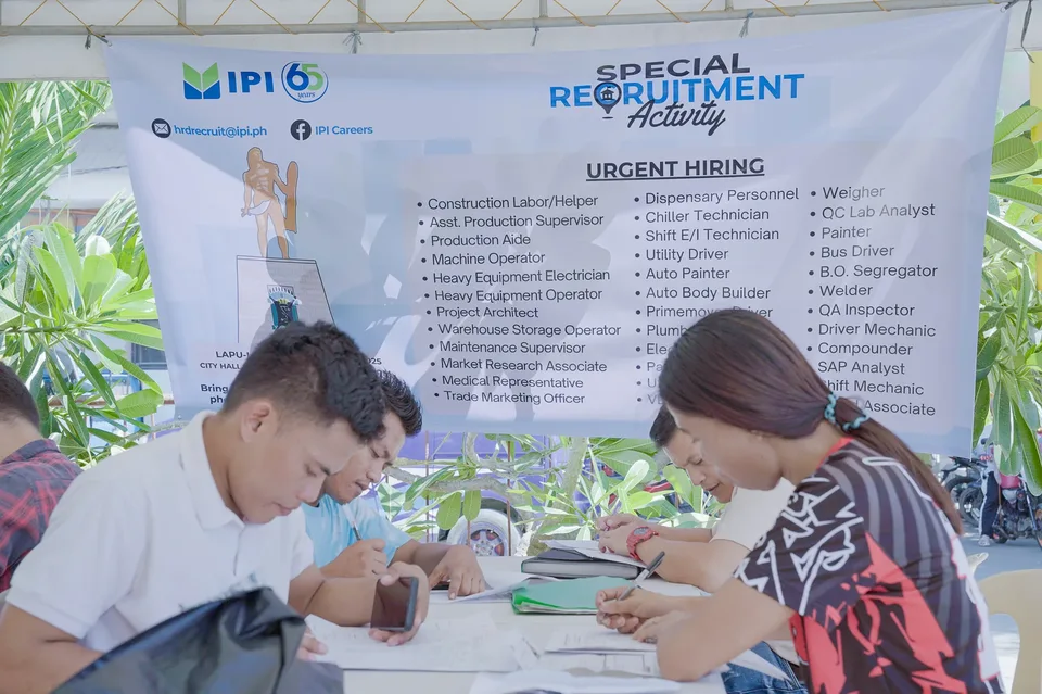Applicants completing forms and meeting IPI recruiters at a PESO special recruitment activity held under tents in the city grounds