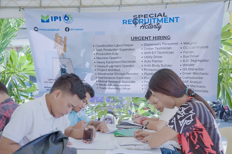 Applicants completing forms and meeting IPI recruiters at a PESO special recruitment activity held under tents in the city grounds