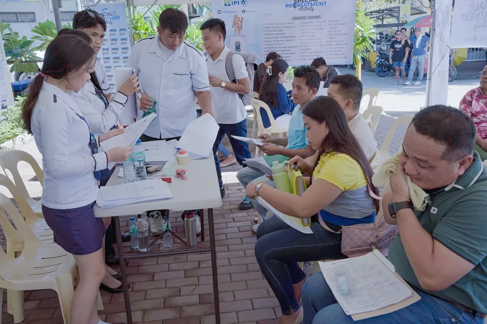 Applicants completing forms and meeting IPI recruiters at a PESO special recruitment activity held under tents in the city grounds