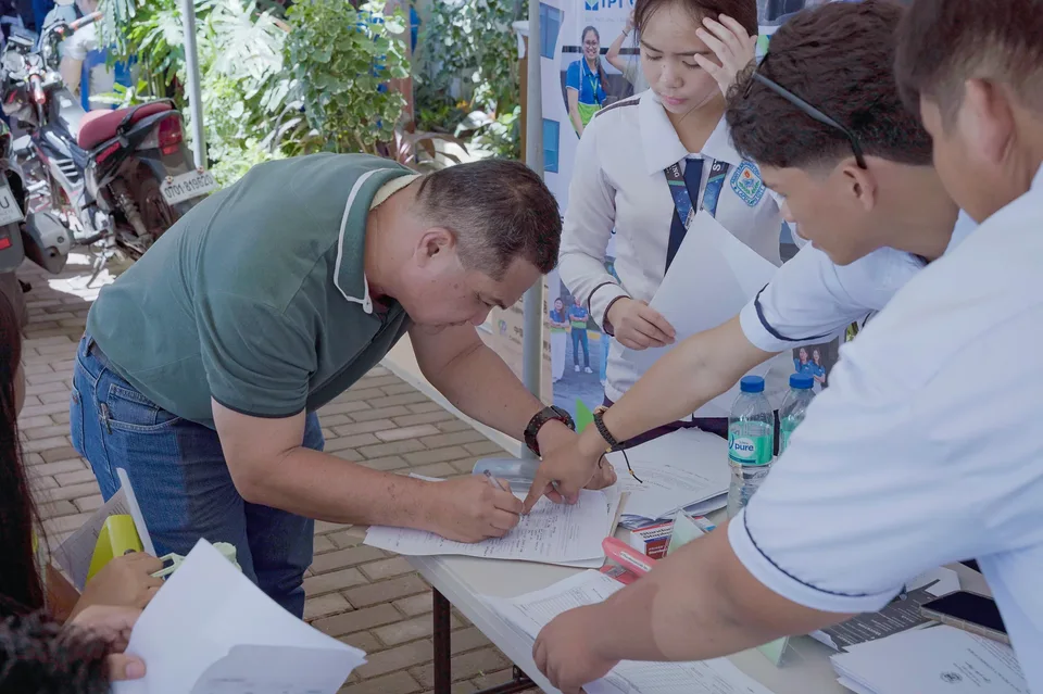 Applicants completing forms and meeting IPI recruiters at a PESO special recruitment activity held under tents in the city grounds