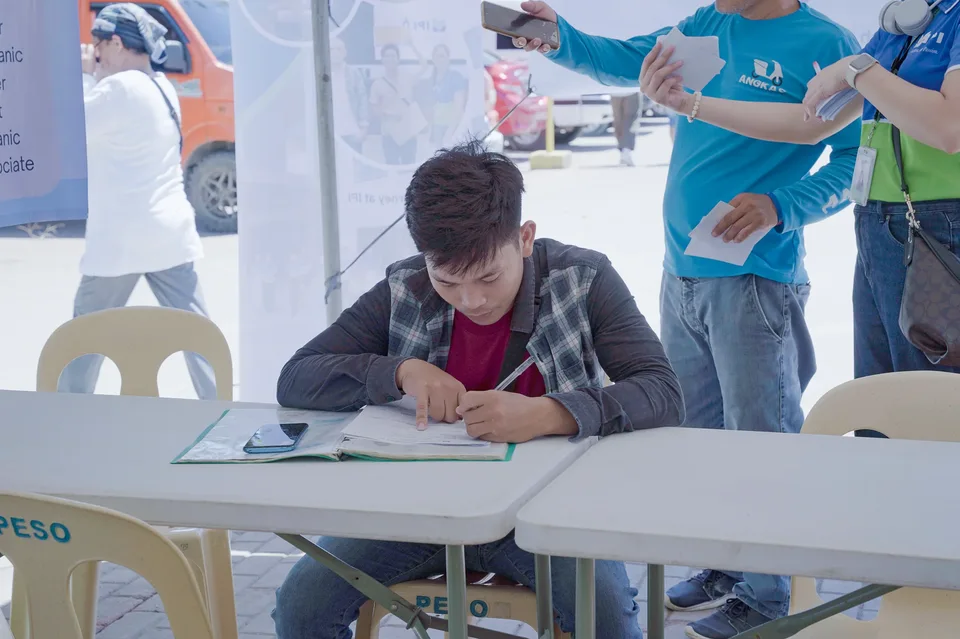 Applicants completing forms and meeting IPI recruiters at a PESO special recruitment activity held under tents in the city grounds