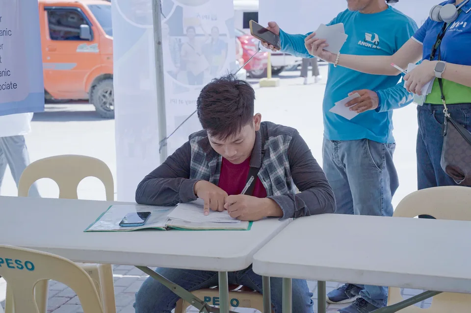 Applicants completing forms and meeting IPI recruiters at a PESO special recruitment activity held under tents in the city grounds