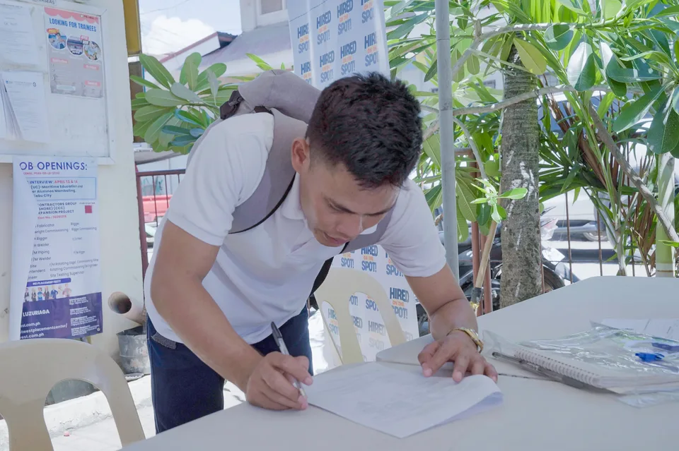 Applicants completing forms and meeting IPI recruiters at a PESO special recruitment activity held under tents in the city grounds